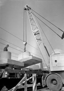 166433 Afbeelding van het beladen van wagens met betonnen voeten voor bovenleidingsmasten bij het Spoorwegbouwbedrijf ...